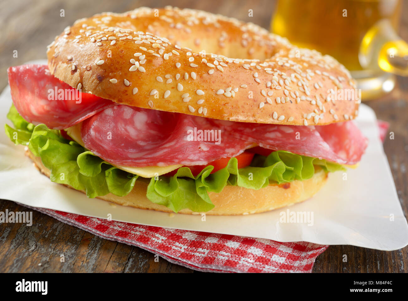 Bagel sandwich with sausage, cheese, and lettuce Stock Photo