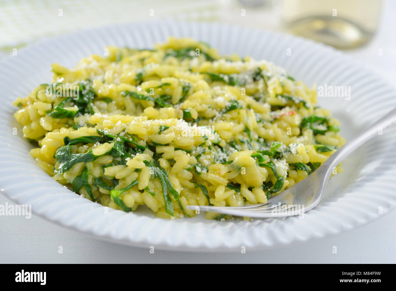 Spinach risotto with saffron and grated Parmesan cheese Stock Photo