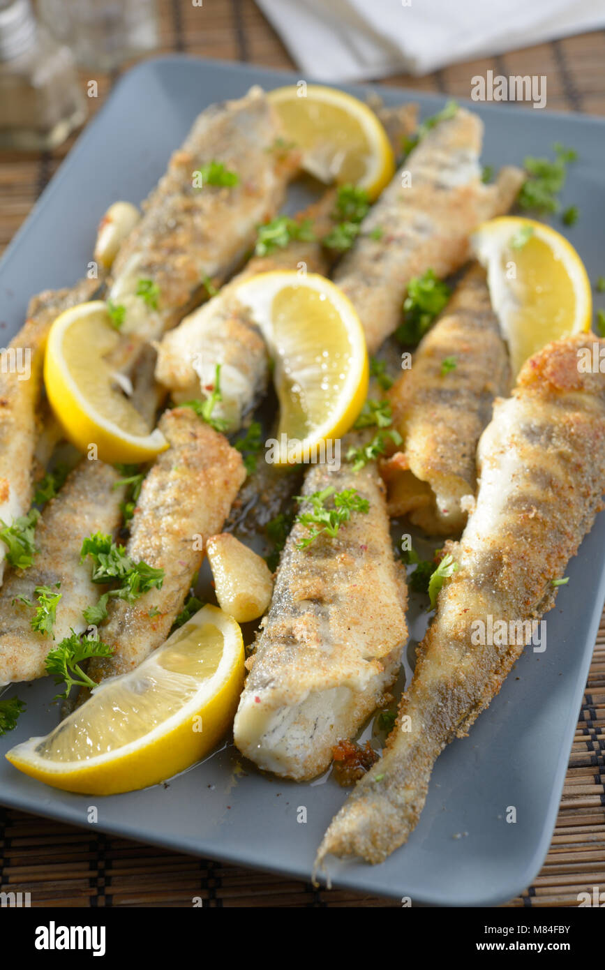Roasted ice fish with lemon and parsley Stock Photo - Alamy