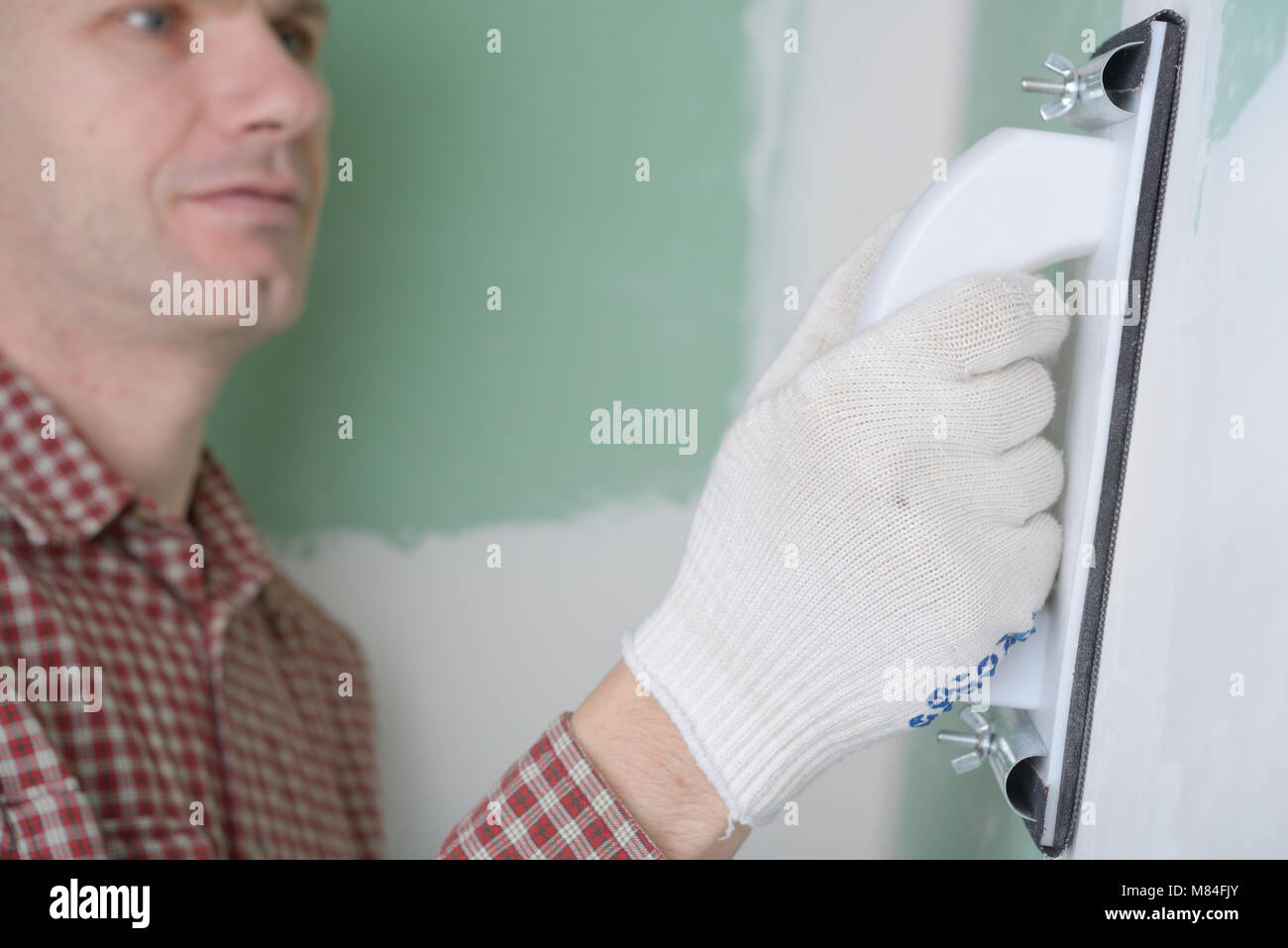Contractor sanding the drywall mud using sand trowel Stock Photo Alamy