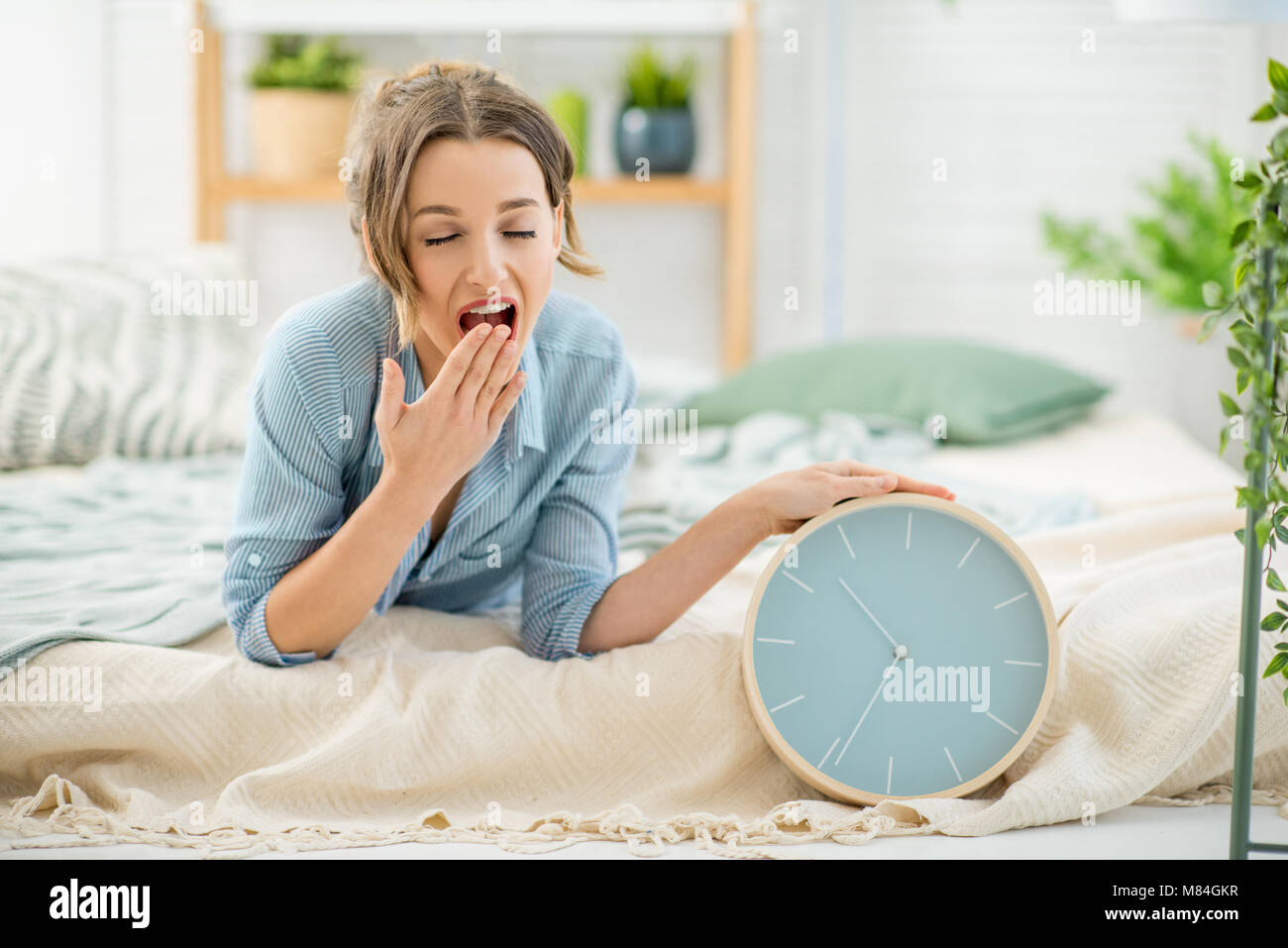 Woman with clock in the bedroom Stock Photo Alamy