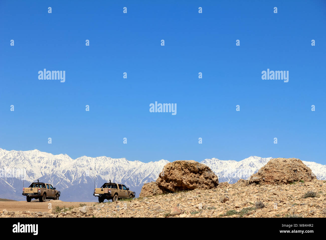 Two afghan military vehicles, two rocks and a mountain. Army Exercise at BlackHorse Camp, Cabul, Afghanistan. Stock Photo