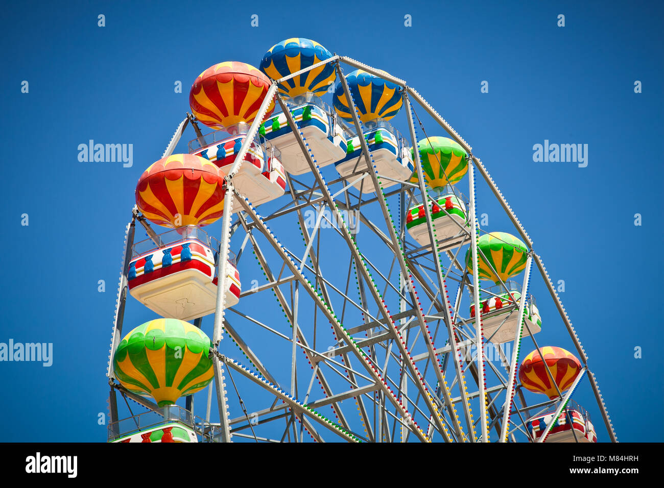 Close-up of colorful ferris wheel on vivid blue sky background Stock ...