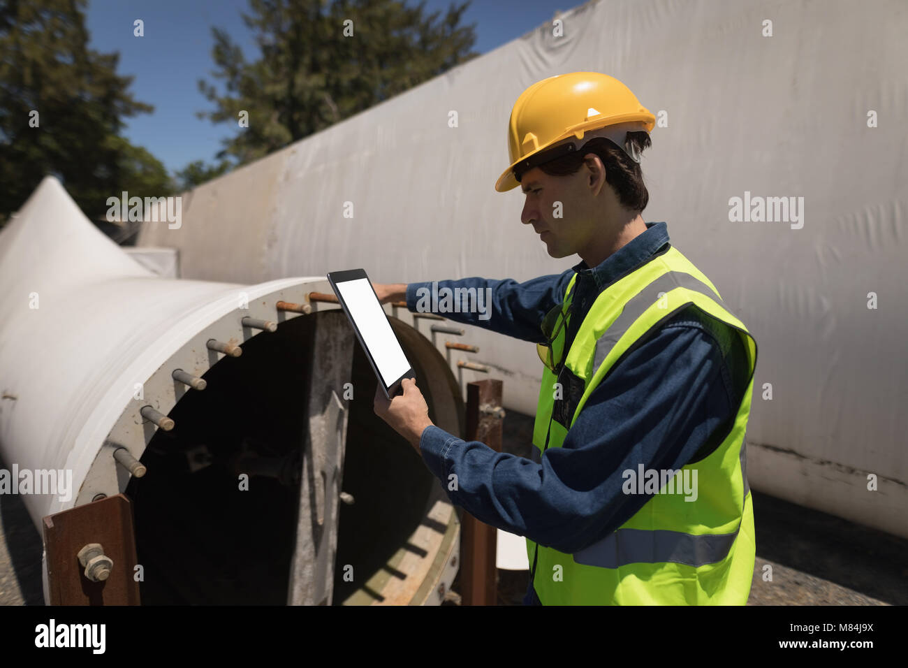 Male worker using digital tablet while examining concrete tunnel Stock Photo