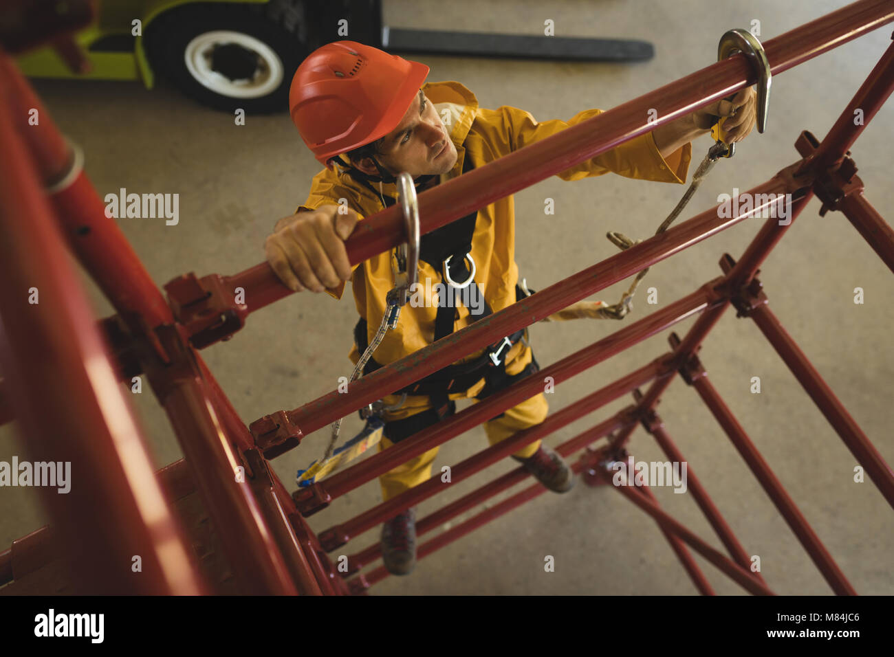 Male worker climbing scaffolding at solar station Stock Photo