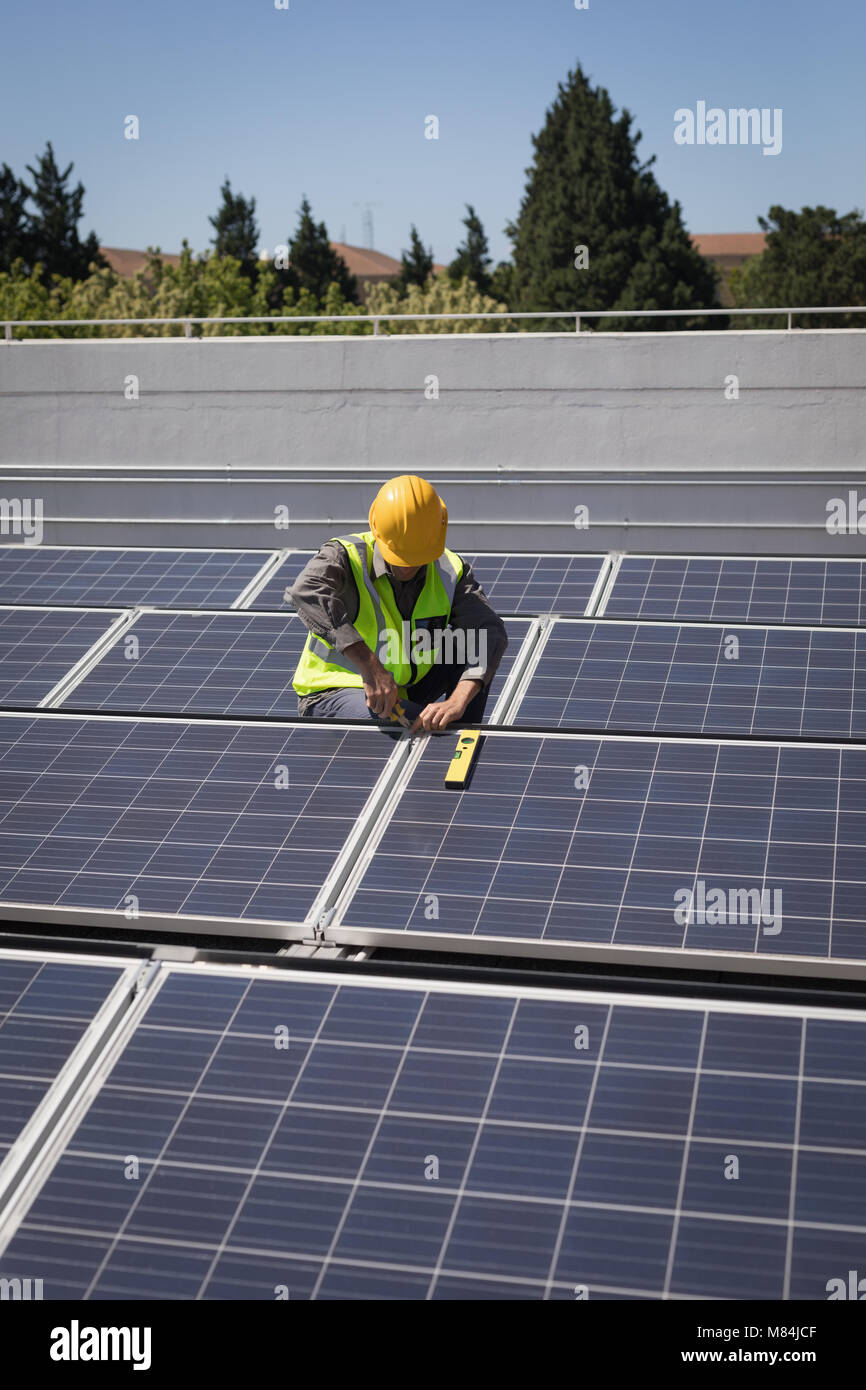 Male worker working on solar panels at solar station Stock Photo