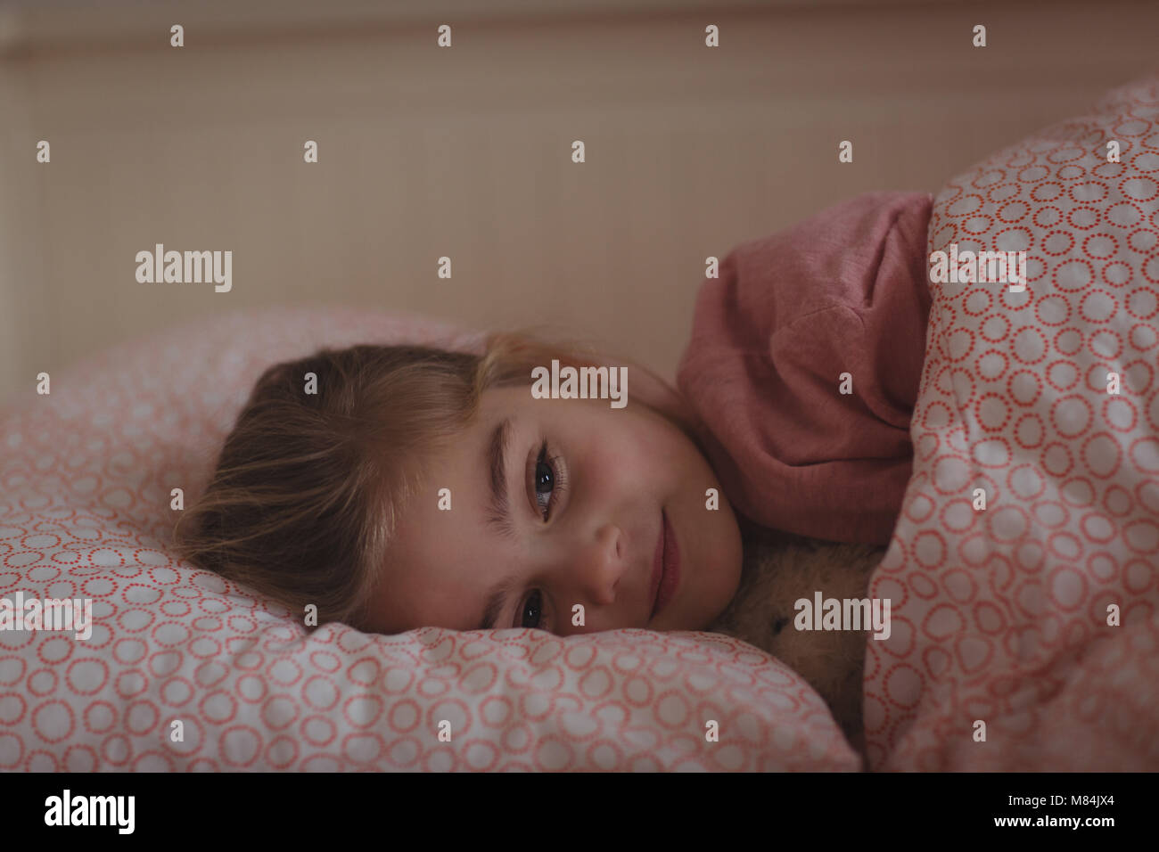 Girl sleeping on bed in bedroom at home Stock Photo