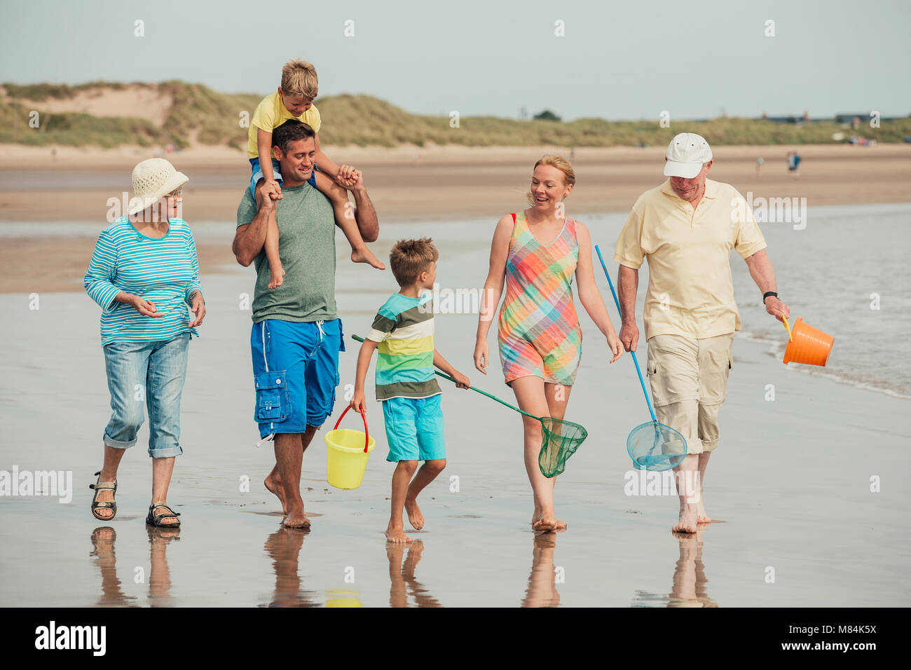 Full length shot of a family walking along the beach Stock Photo Alamy