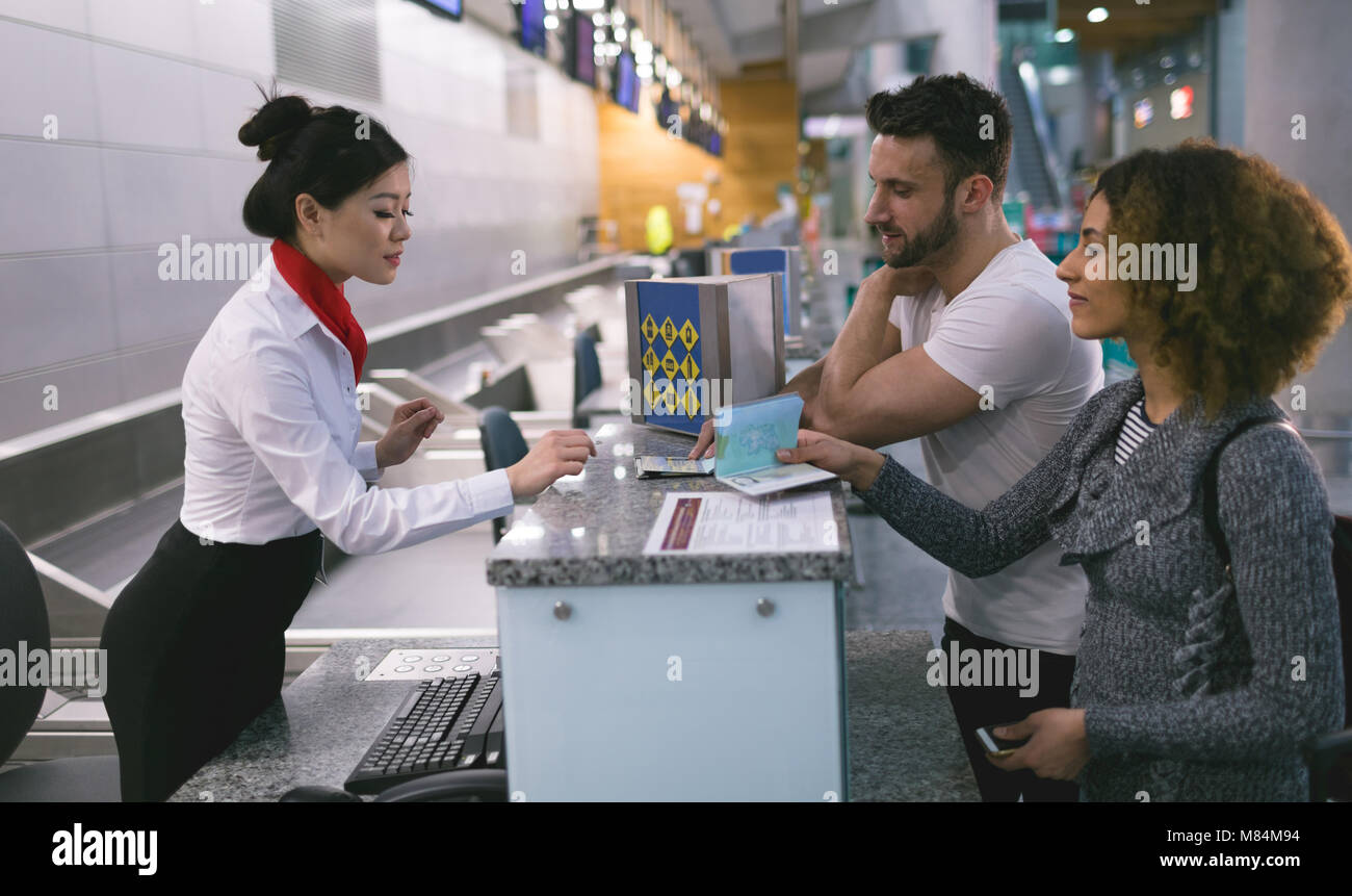 Arline attendant interacting with commuters at counter Stock Photo Alamy