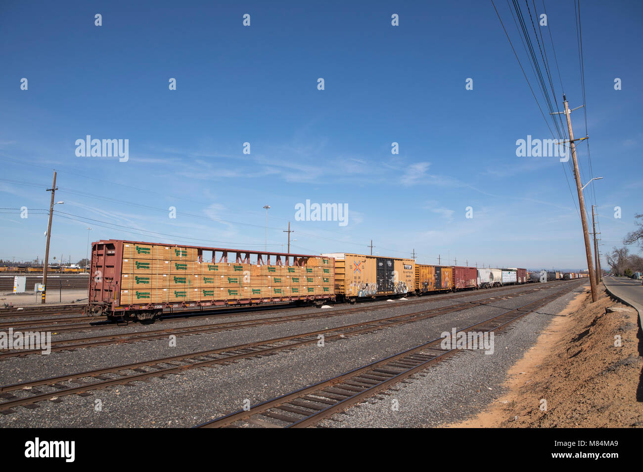 Back end of a long goods train in the shunting yards of Roseville California. Pacific Union rolling stock disappearing into the distance. Stock Photo