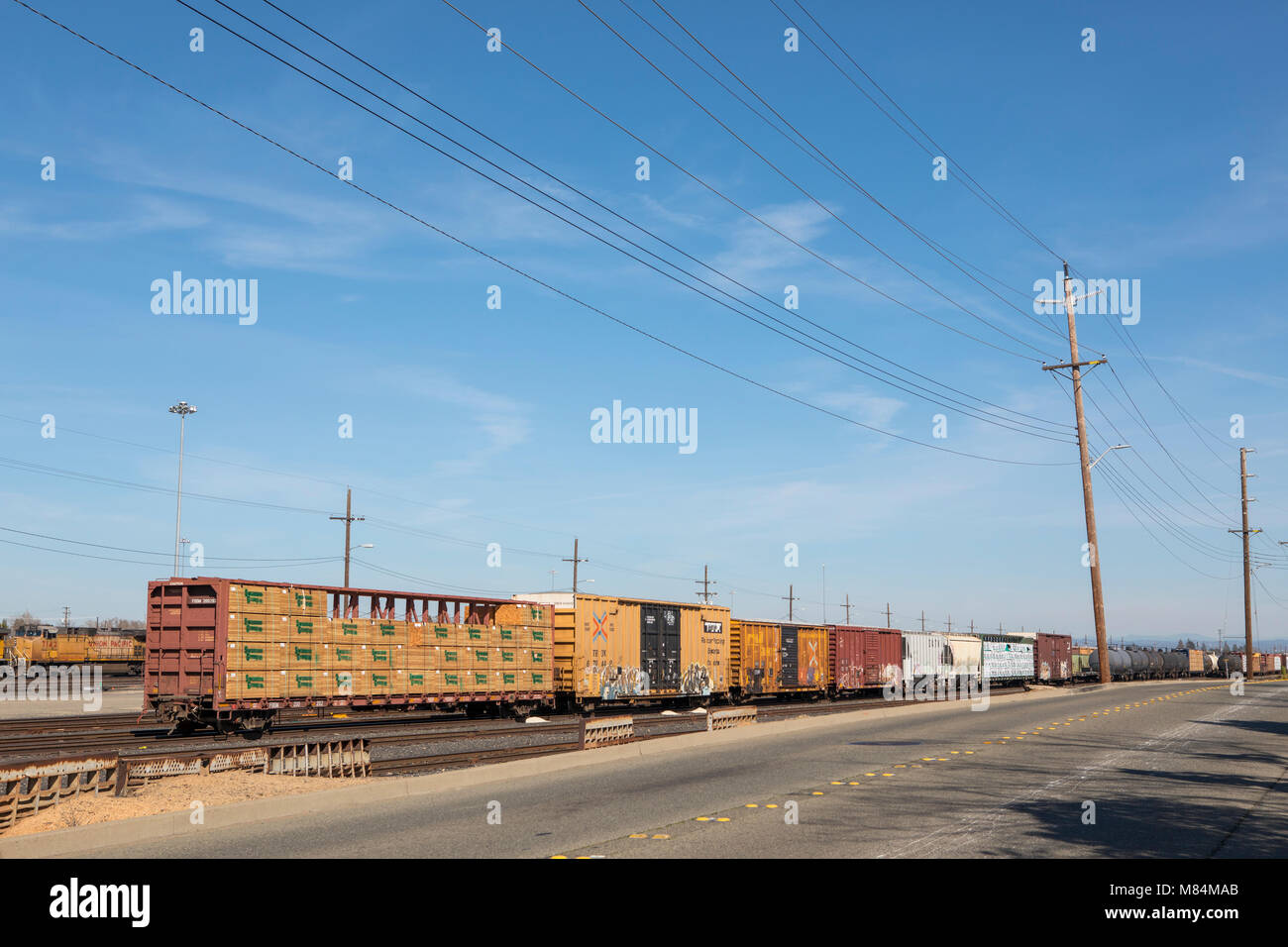 Back end of a long goods train in the shunting yards of Roseville California. Pacific Union rolling stock disappearing into the distance. Stock Photo