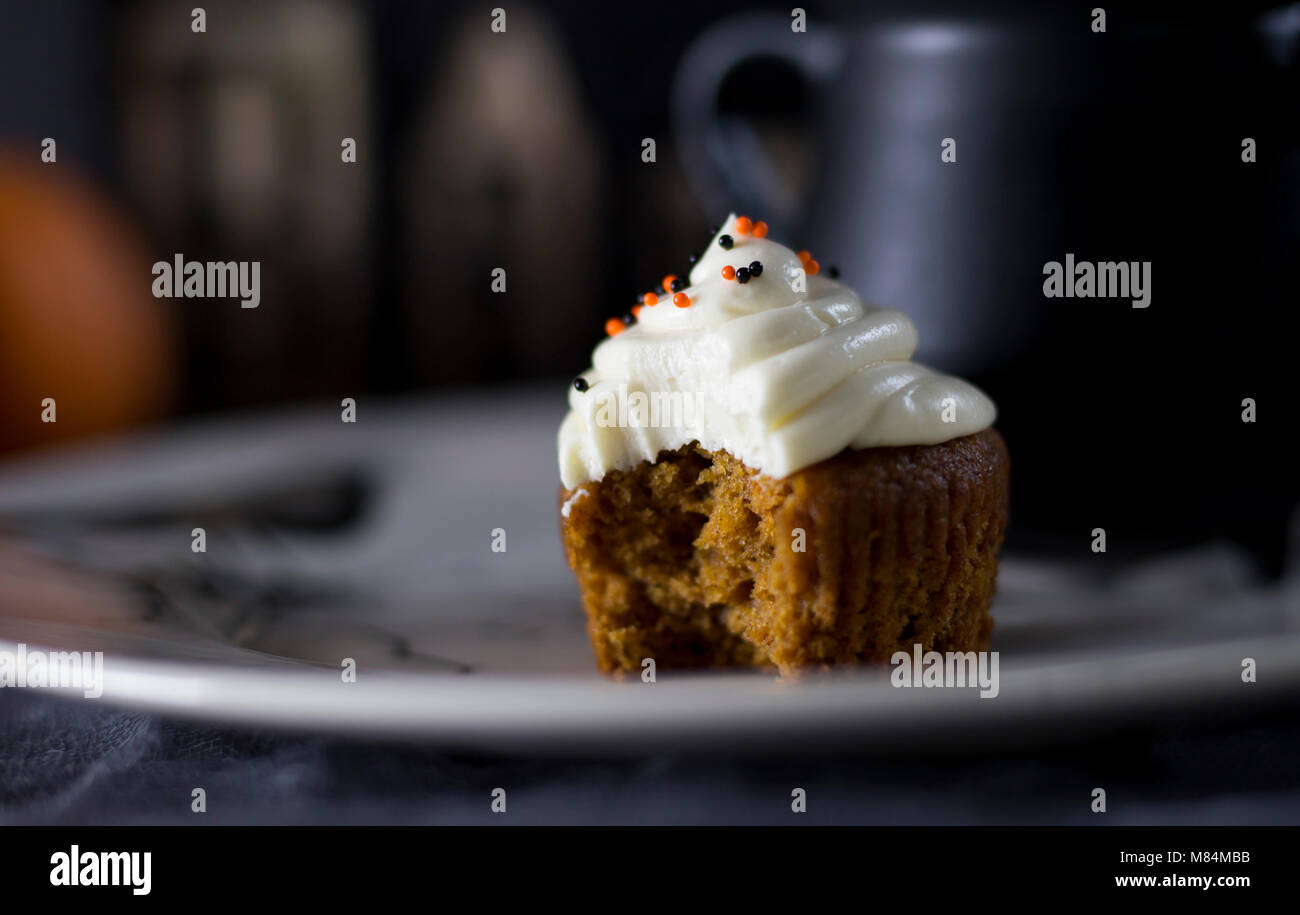 Delicious Pumpkin Halloween Themed Cupcake on a White Plate Stock Photo