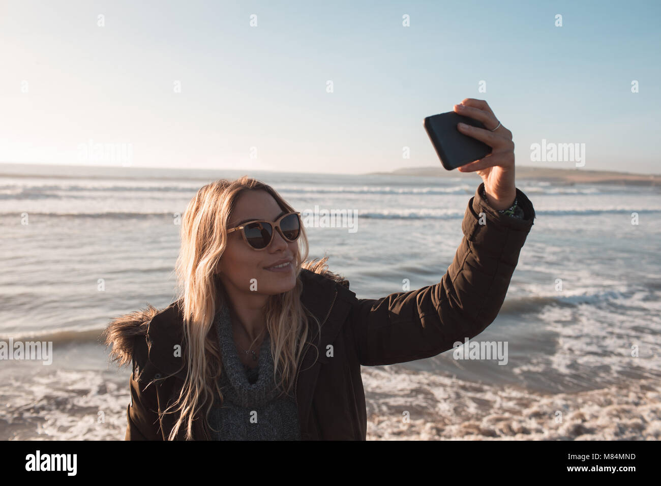 Woman taking selfie with mobile phone at beach Stock Photo - Alamy