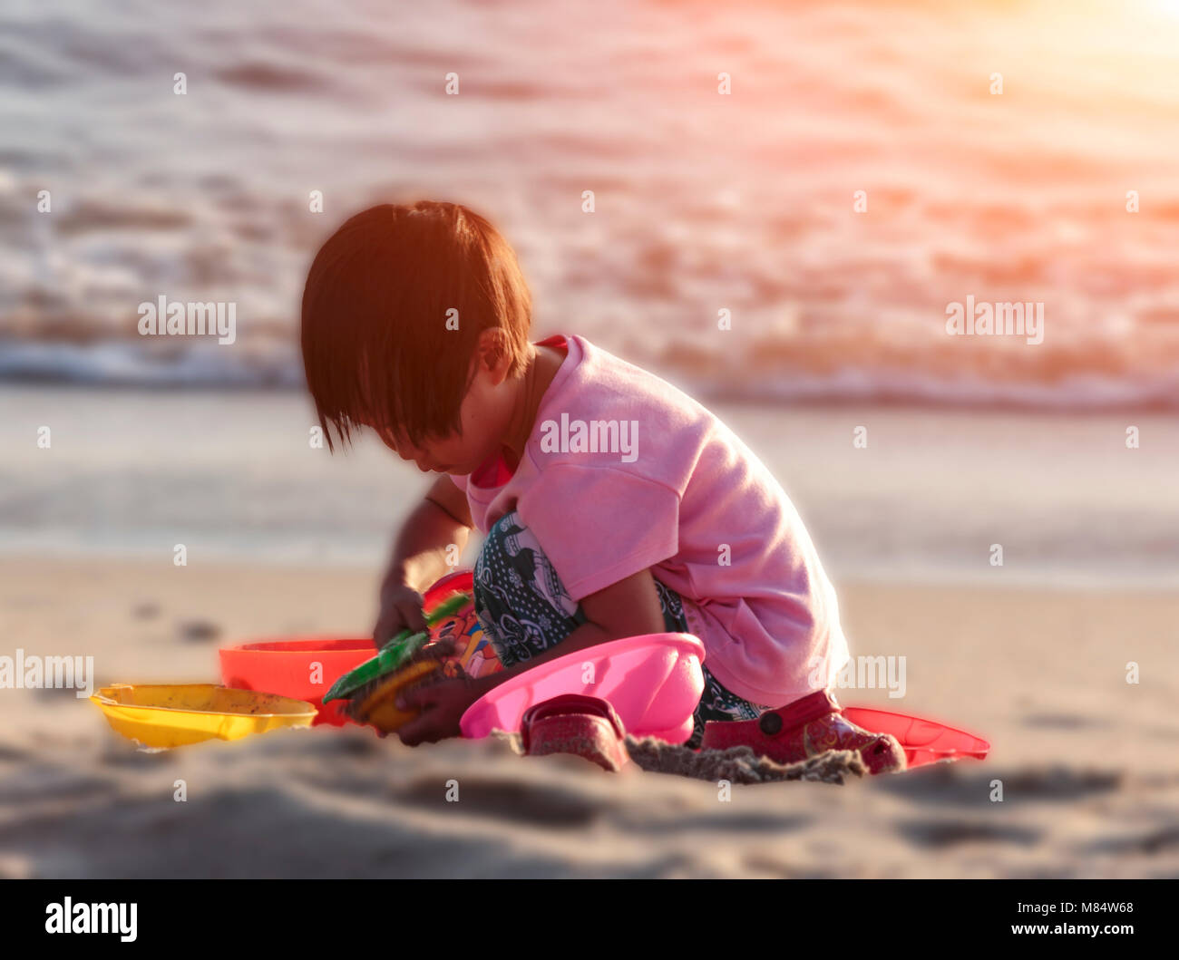 Children with toys in the morning by the sea. Stock Photo