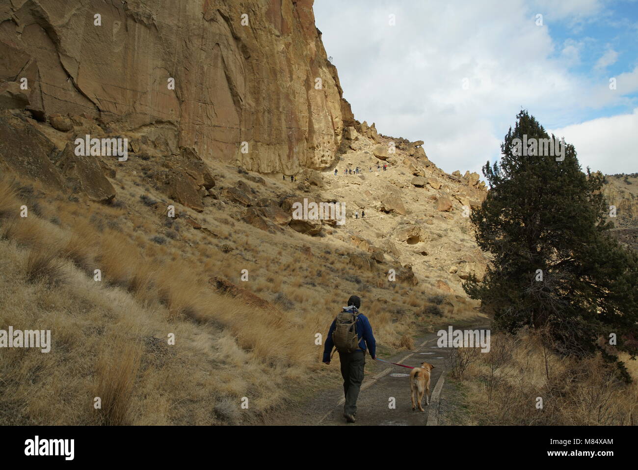 Active senior out walking his dog at an iconic Oregon State park in Central Oregon called Smith Rock. Stock Photo