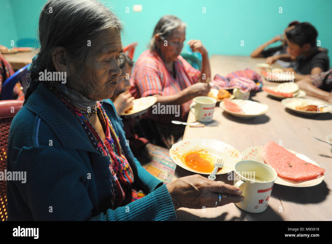 Maya indigenous elderly women at lunch provided by local NPO program in San Jorge La Laguna, Solola, Guatemala. Stock Photo
