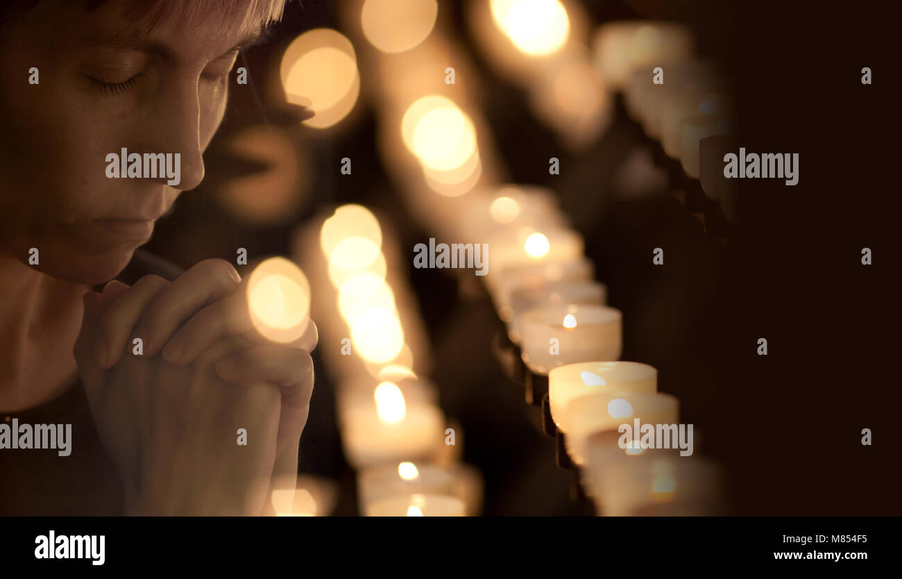 Woman praying in Catholic church Stock Photo