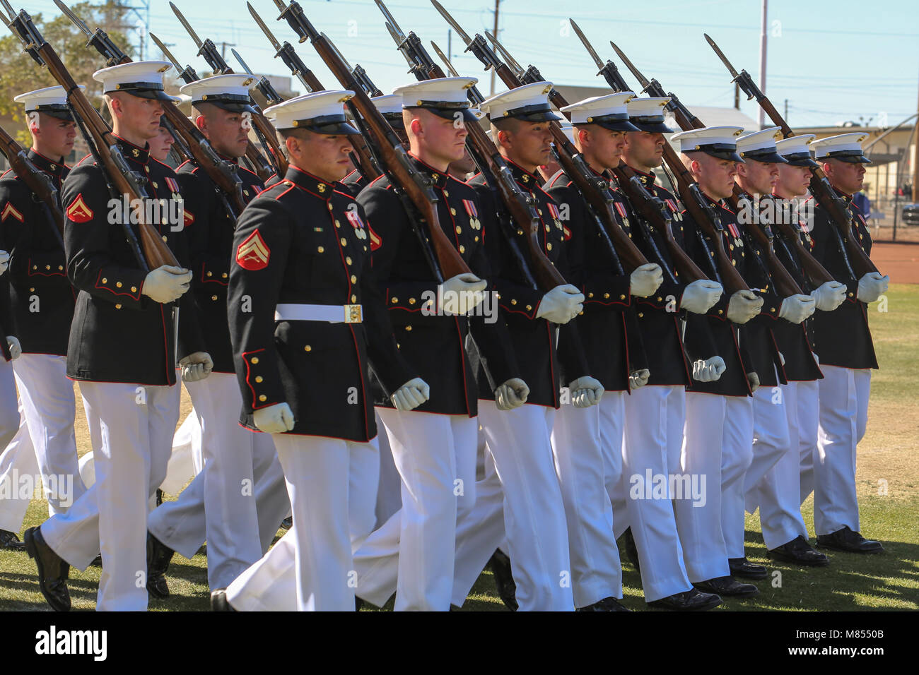 The U.S. Marine Corps Silent Drill Platoon marches during the “pass in review” for a dress rehearsal of the Battle Color ceremony at Marine Corps Air Station Yuma, Yuma, Az., March 2, 2018. This dress rehearsal marks the end of the Marines’ month-long training phase in Yuma. The Marines will move on to display their hard work and dedication during their performances on the West Coast Tour and throughout the 2018 parade season.(Official Marine Corps photo by Cpl. Damon Mclean/Released) Stock Photo