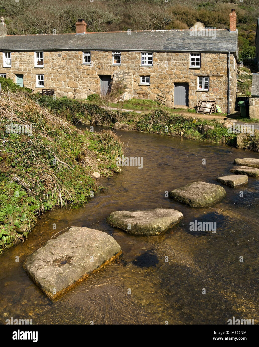 Old cottages and stepping stones across river at Penberth Cove, Cornwall, England, UK. Location was used during filming of Poldark TV series. Stock Photo