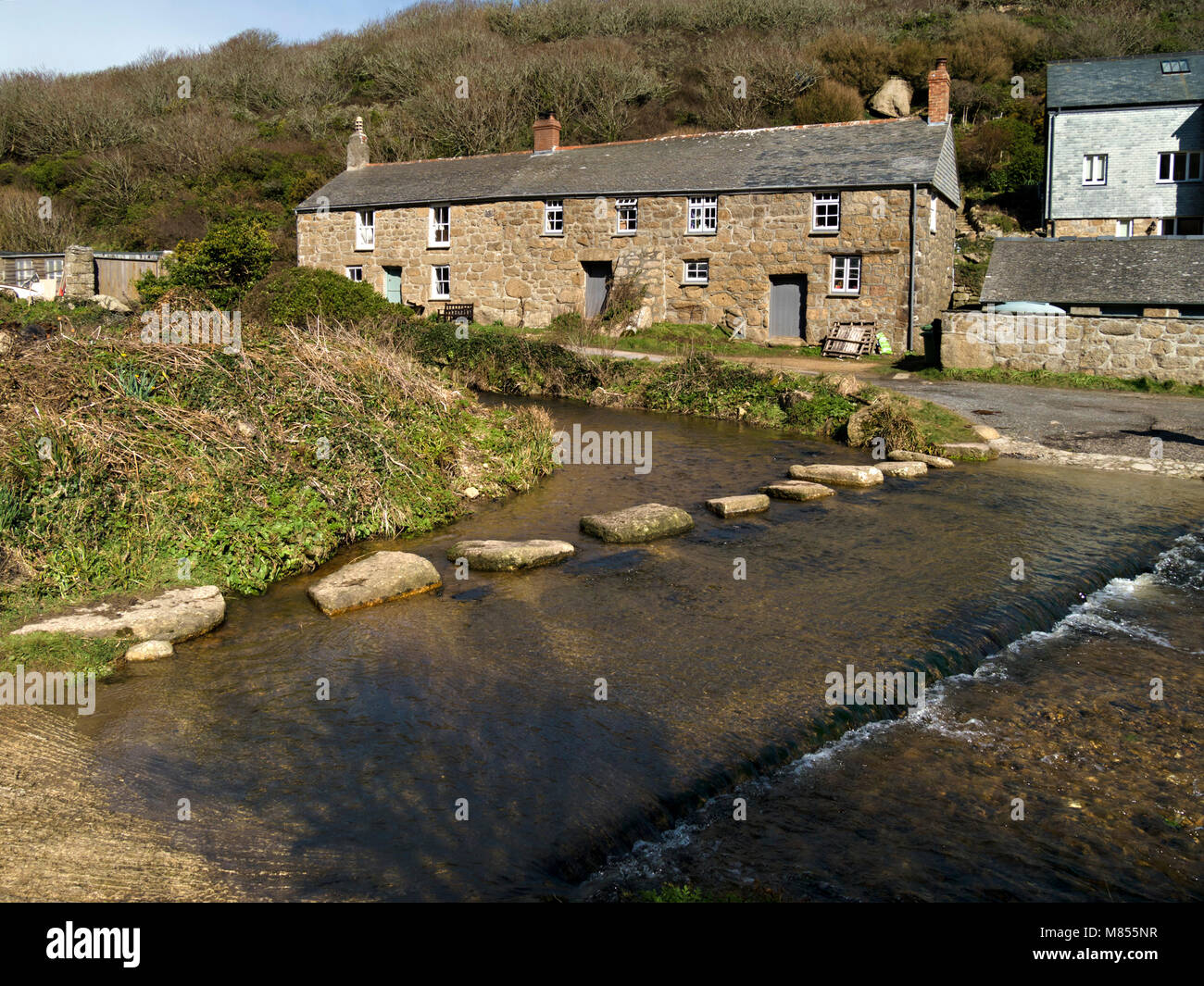 Old cottages, stepping stones and ford across river at Penberth Cove, Cornwall, England, UK. Location was used during filming of Poldark TV series. Stock Photo