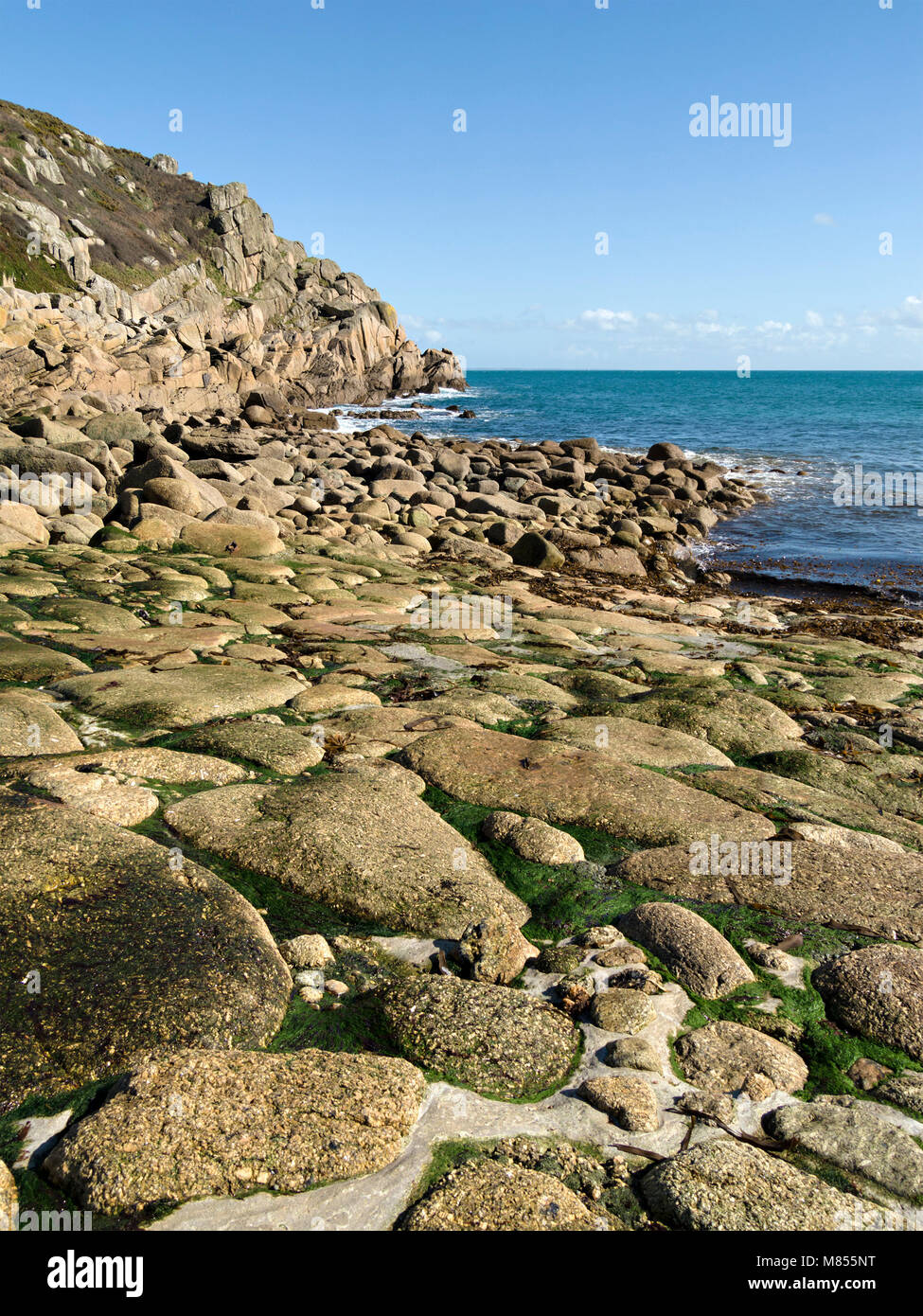 Stone boat slipway, rocky cliffs and sea, Penberth Cove harbour, Cornwall, England, UK Stock Photo