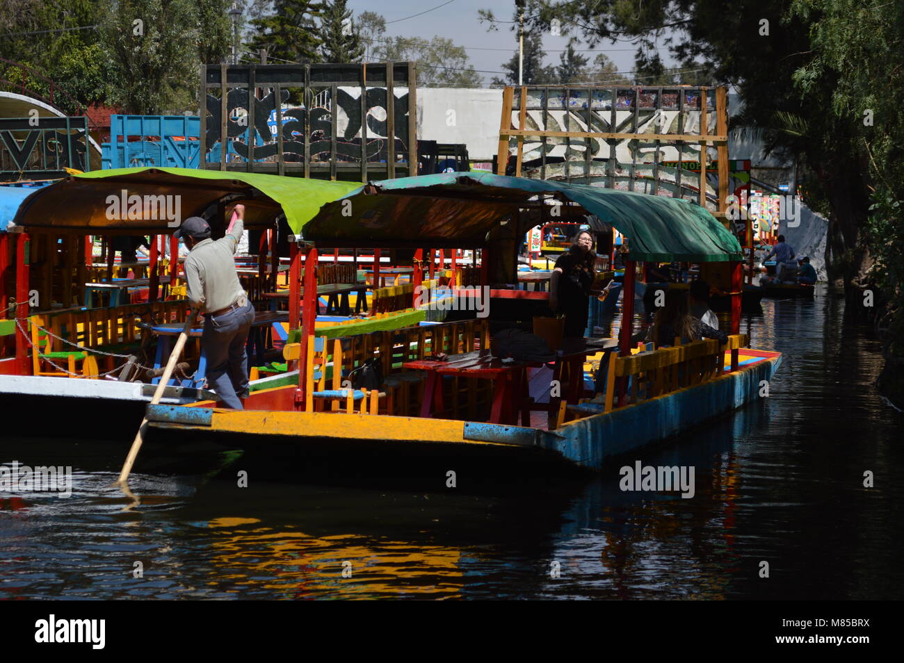A man steering a trajinera in Xochimilco, Mexico City Stock Photo