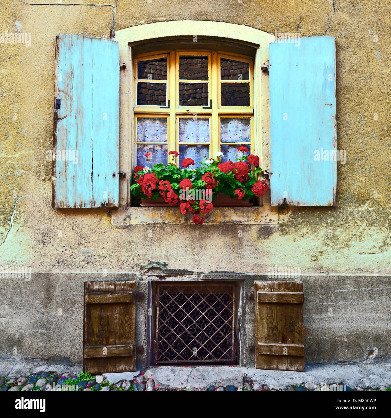 Painted shutters and a window box add a splash of colour to a medieval house in Eguisheim, Alsace, France. Stock Photo
