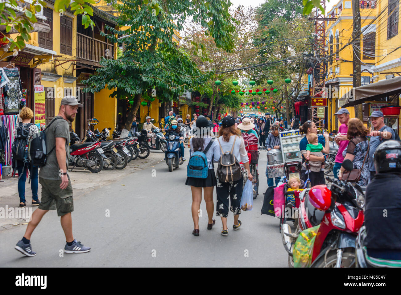 People walking down a street in Hoi An, Vietnam Stock Photo