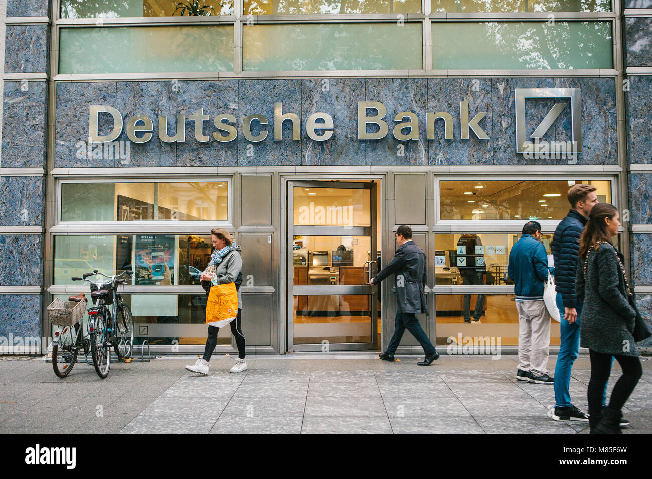 Unknown man walks into the beautiful glass office of Deutsche Bank Stock Photo