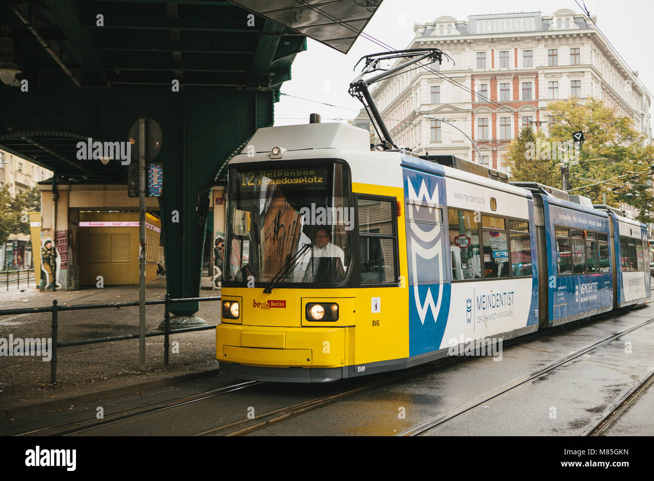 Berlin, October 2, 2017: City public transport in Germany. Beautiful black and yellow train stopped at stop on the background of an old building Stock Photo