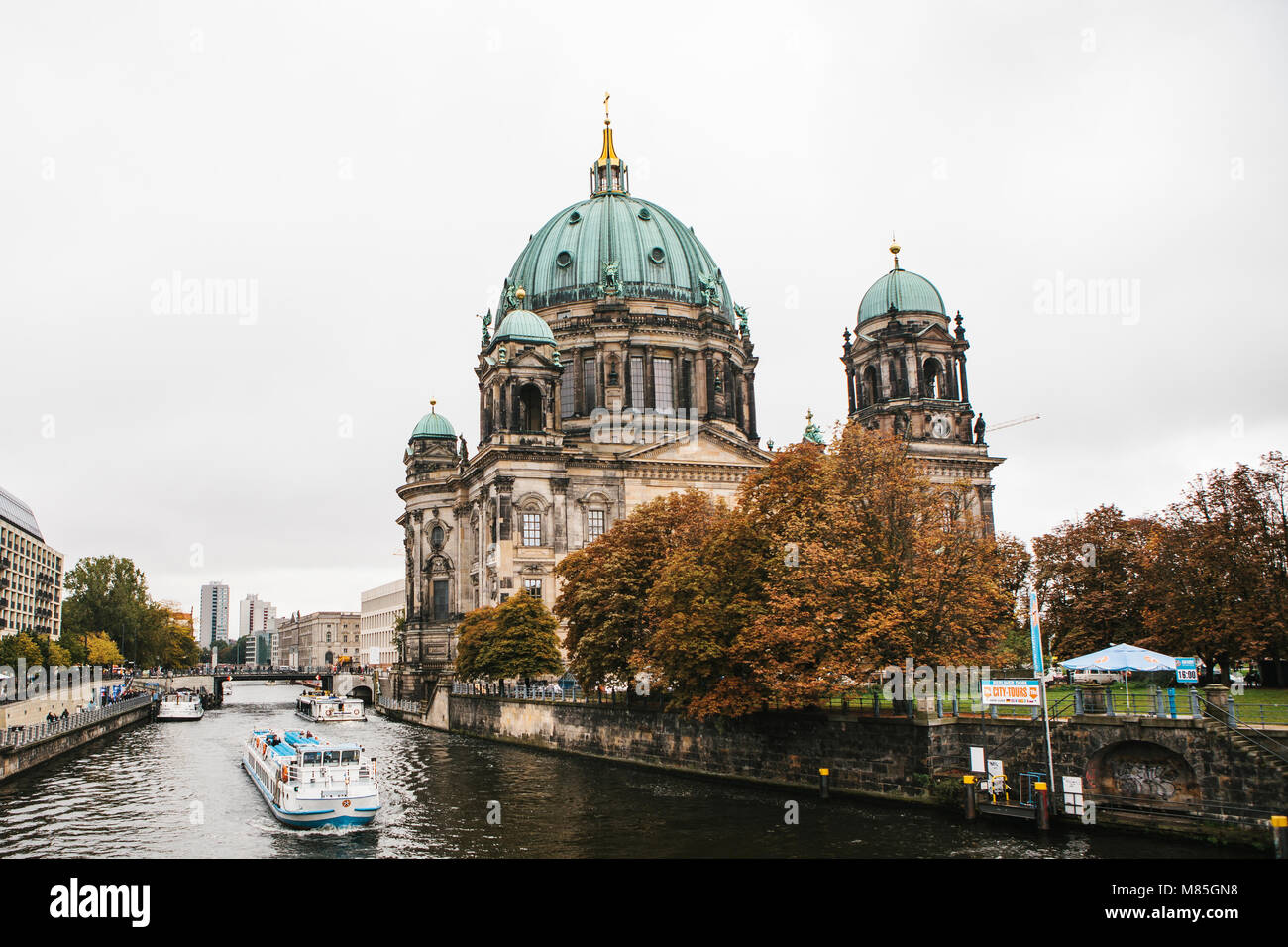 Berlin, October 1, 2017: Berlin Cathedral Berliner dom- beautiful old building with green dome next to the river Spree and tourist boats Stock Photo