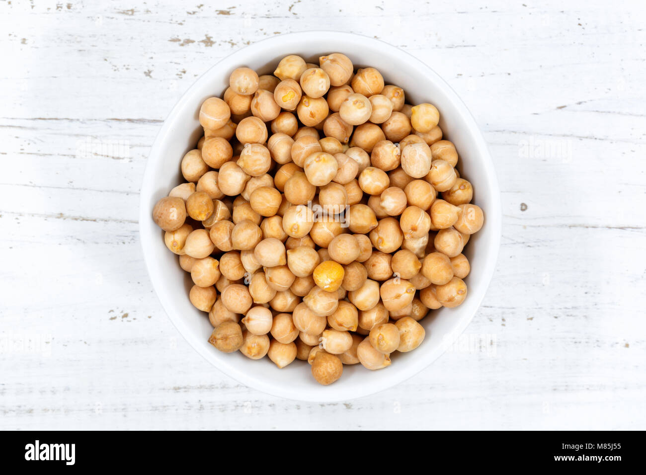 Chickpeas peas raw from above bowl wooden board wood Stock Photo