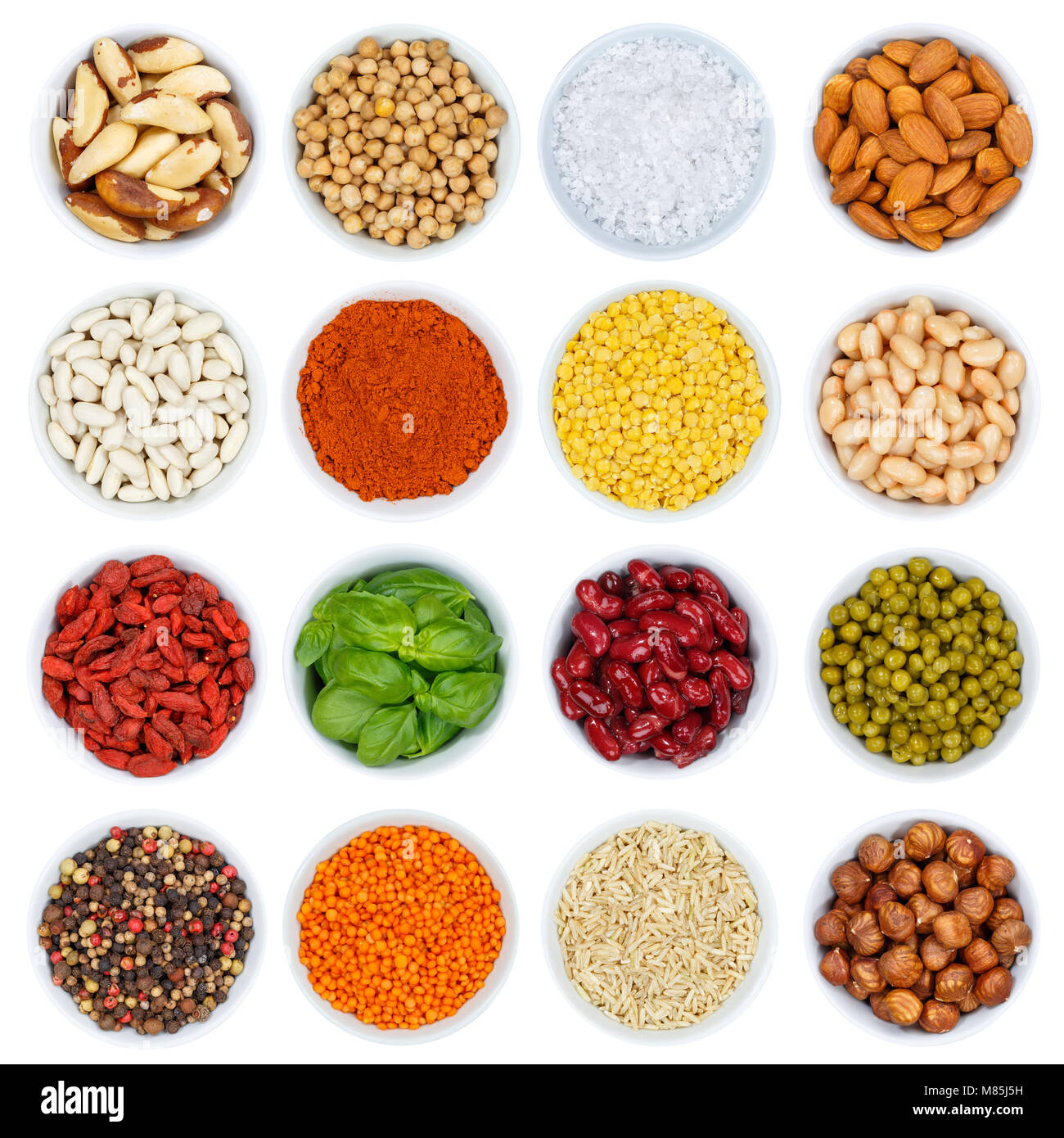 Collection of spices and herbs vegetables nuts from above bowl isolated on a white background Stock Photo