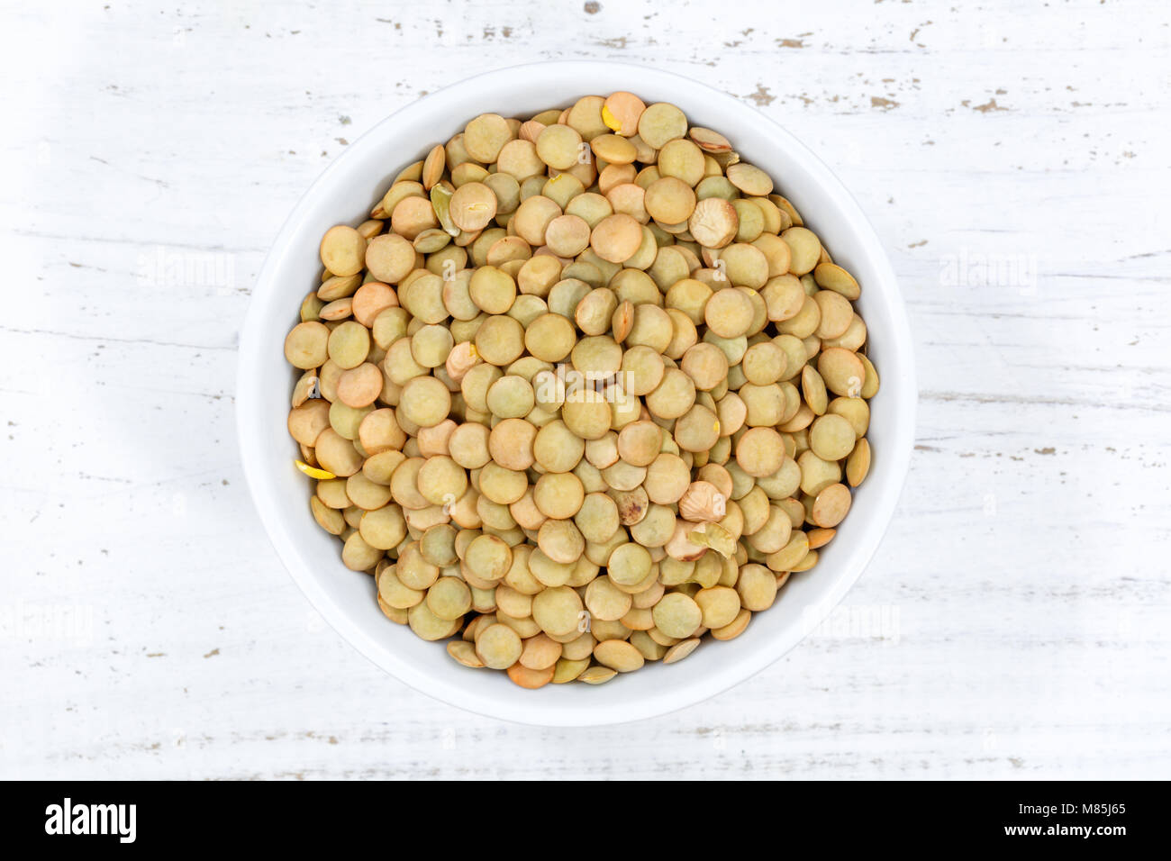 Green lentils raw from above bowl wooden board wood Stock Photo