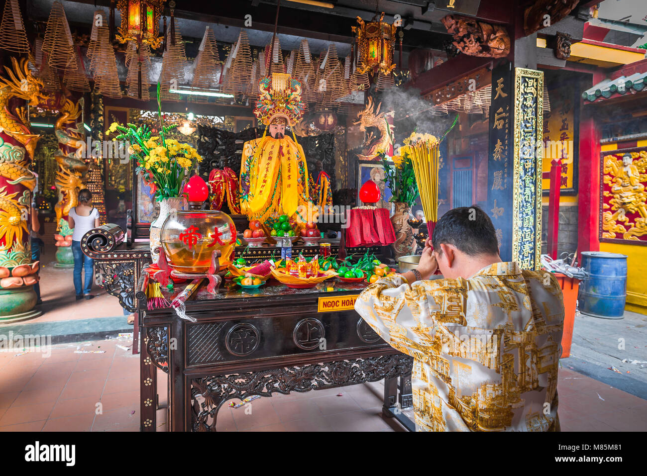 Ho Chi Minh City temple, rear view of a man worshipping inside the Quan Am pagoda in the Cholon area of Ho Ci Minh City (Saigon) Vietnam. Stock Photo
