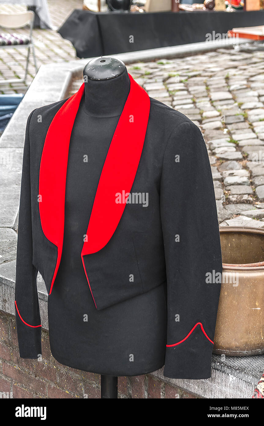 a coat hanging outside with a red lapel Stock Photo