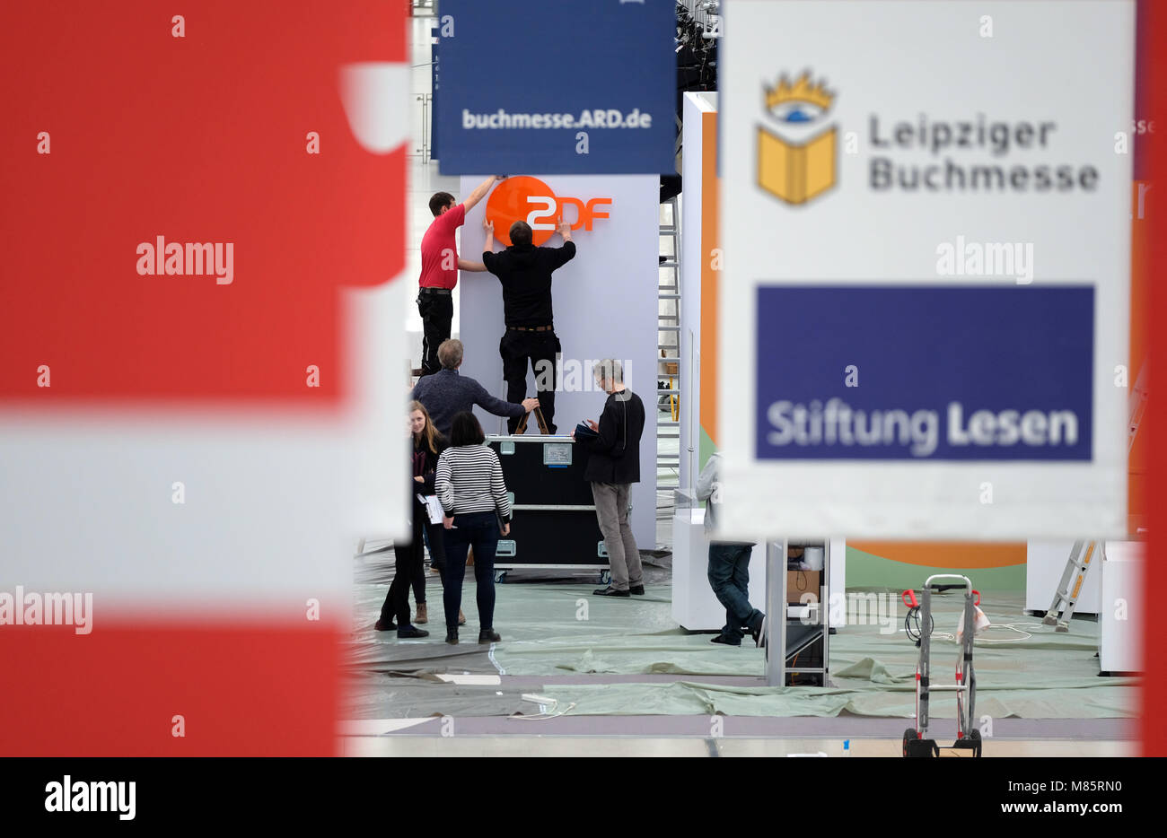 14 March 2018, Germany, Leipzig: Staff members decorate a fair stand of German public broadcaster and television station 'Zweites Deutsches Fernsehen (ZDF)' at the Leipzig Book Fair. Around 2,600 exhibitors are going to present their novelities from the world of literature at the fair which runs from 15 March to 18 March 2018. Photo: Sebastian Willnow/dpa-Zentralbild/dpa Stock Photo