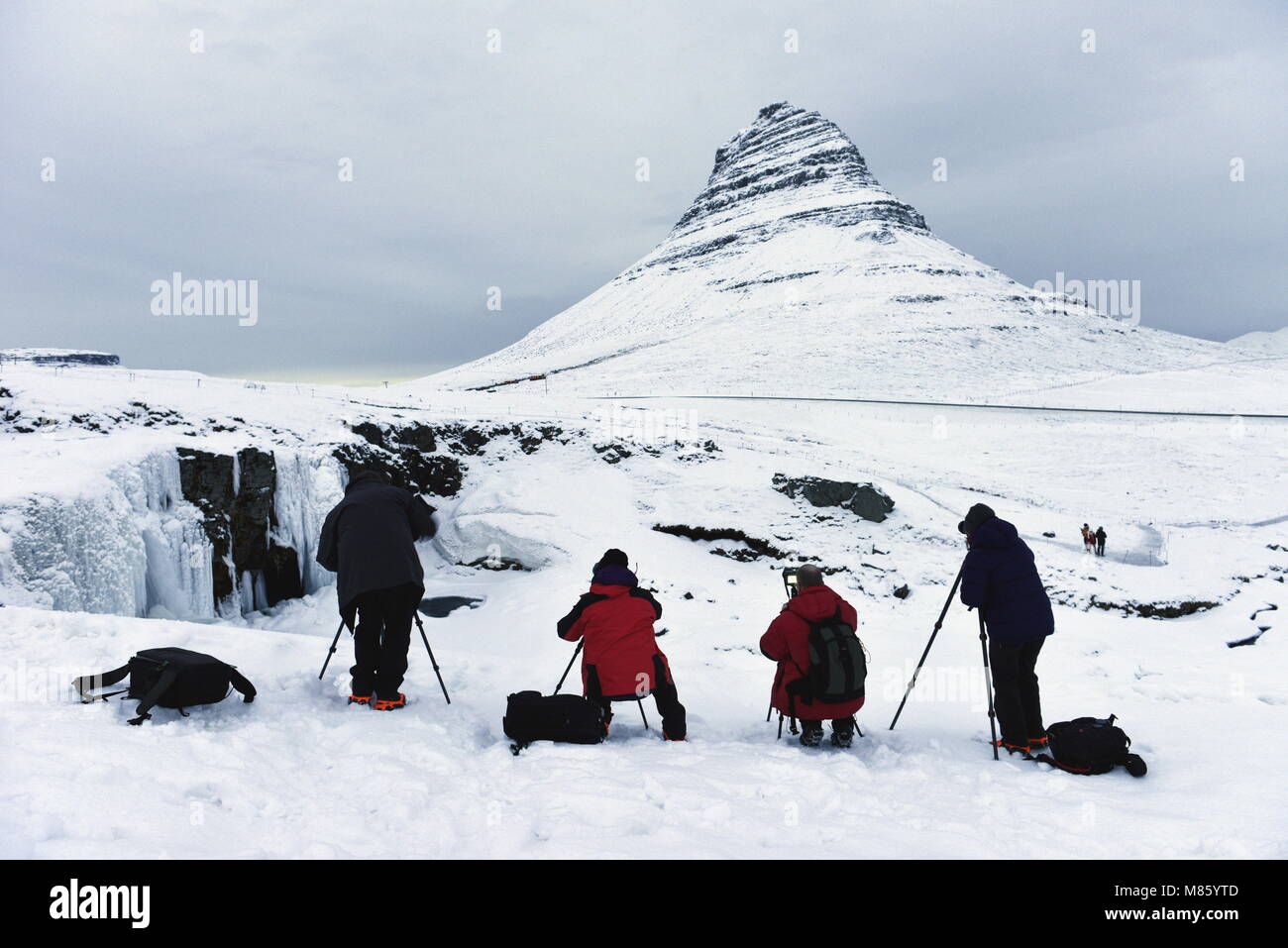 Grundarfjordur, Iceland. 14th March, 2018. Photographers line up to photograph Kirkjufell mountain in the snow. The mountain is famous for its similar appearance to the sorting hat in the Harry Potter films. The Icelandic government recently expressed concerns about the impact of tourism on the natural environment in Iceland. Credit: Glyn Thomas Photography/Alamy Live News Stock Photo