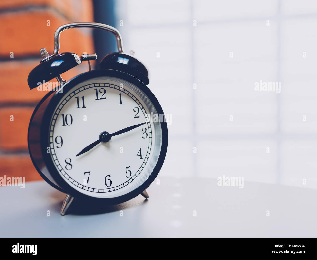 Retro alarm clock on table with vintage background Stock Photo - Alamy
