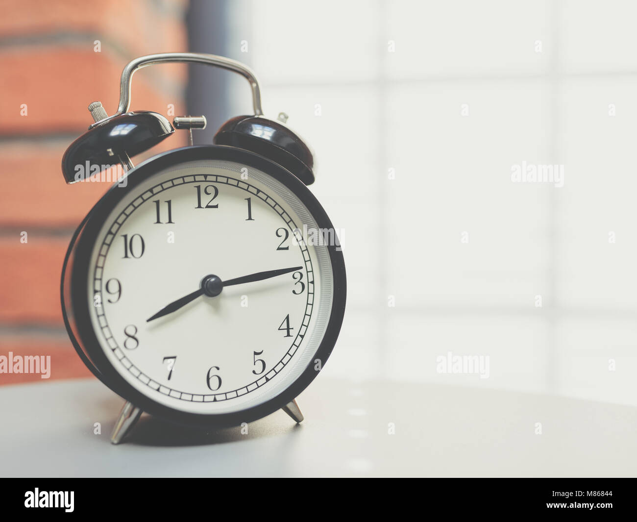 Retro alarm clock on table with vintage background Stock Photo - Alamy