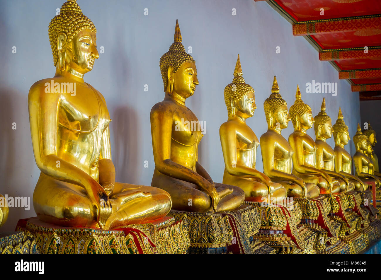 Indoor view of nice Gold Buddha Statues in a row in Wat Pho Temple in Thailand Stock Photo