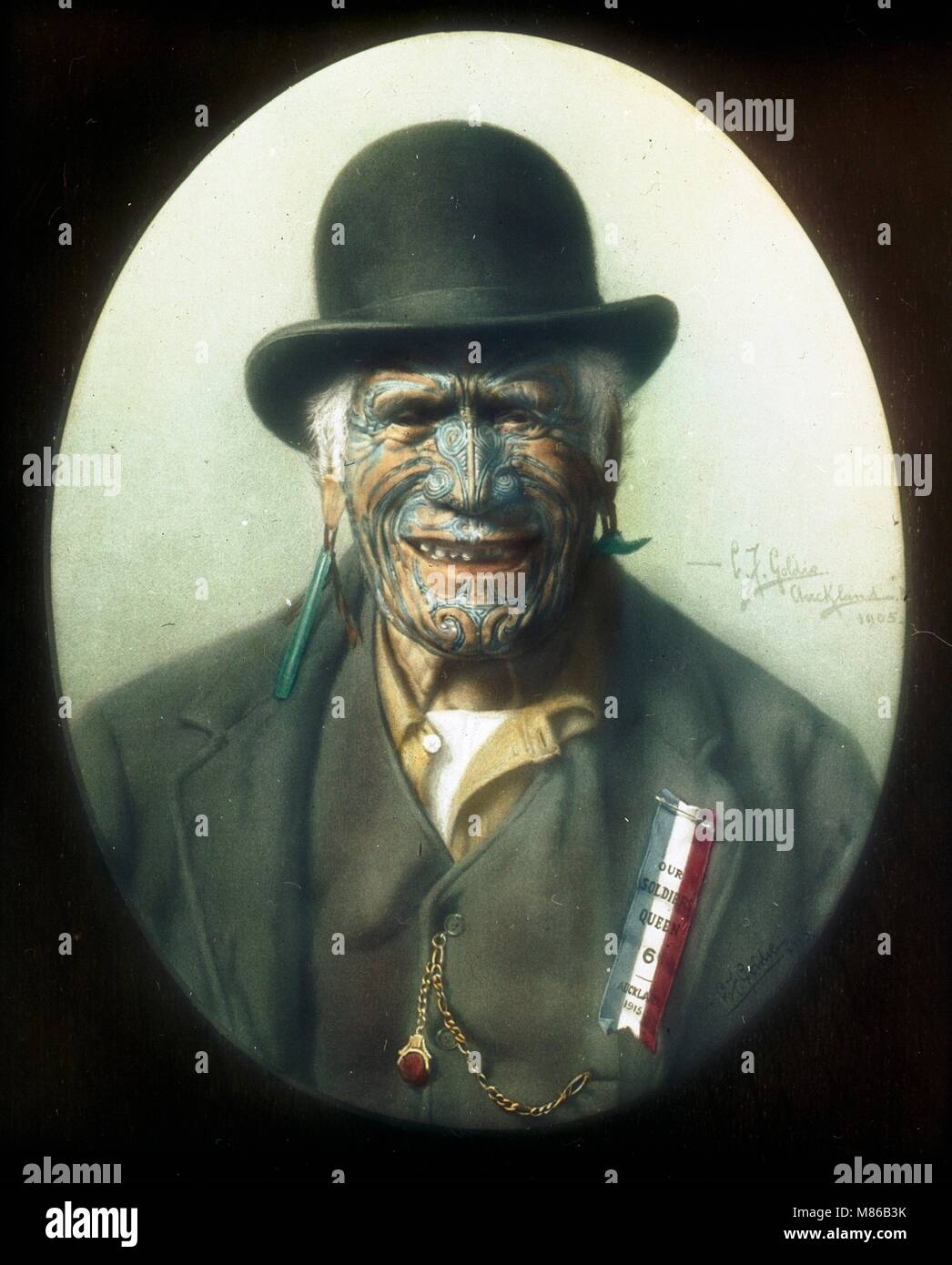 Colorized portrait of Maori warrior and chief Te Aho-o-te-Rangi Wharepu (1811-1910) wearing a derby hat and ‘Our Soldiers Queen, Auckland 1915’ badge, Auckland, New Zealand, 1917. Originally photographed by Charles Goldie in 1905 and colorized by Burton Holmes in 1917. (Photo by Charles Goldie) Stock Photo