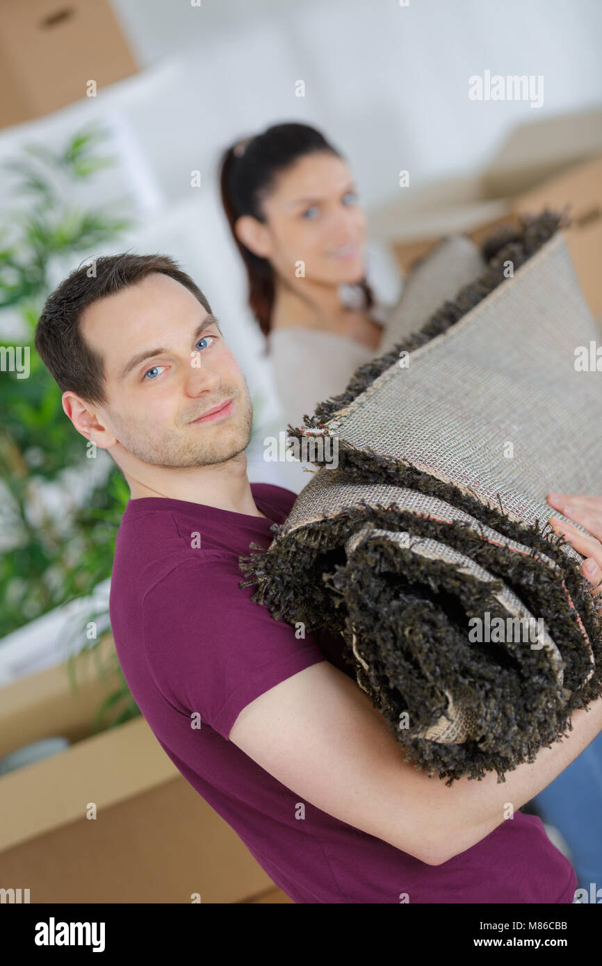 couple carrying a heavy carpet Stock Photo Alamy