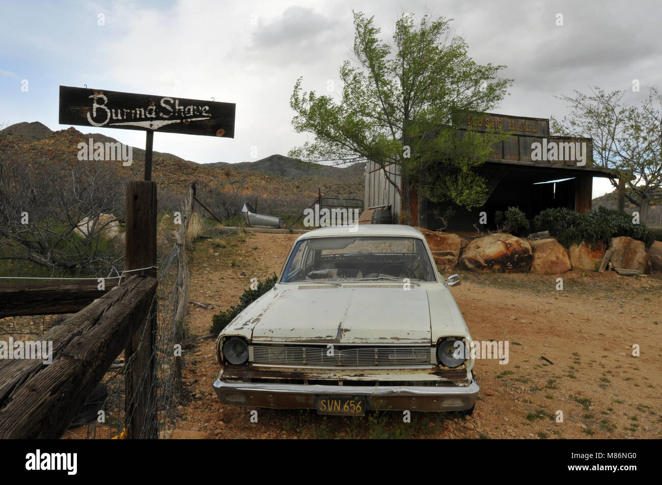 An old car and Burma-Shave advertising sign stand near a weathered wooden building behind the Hackberry General Store, a Route 66 landmark in Arizona. Stock Photo