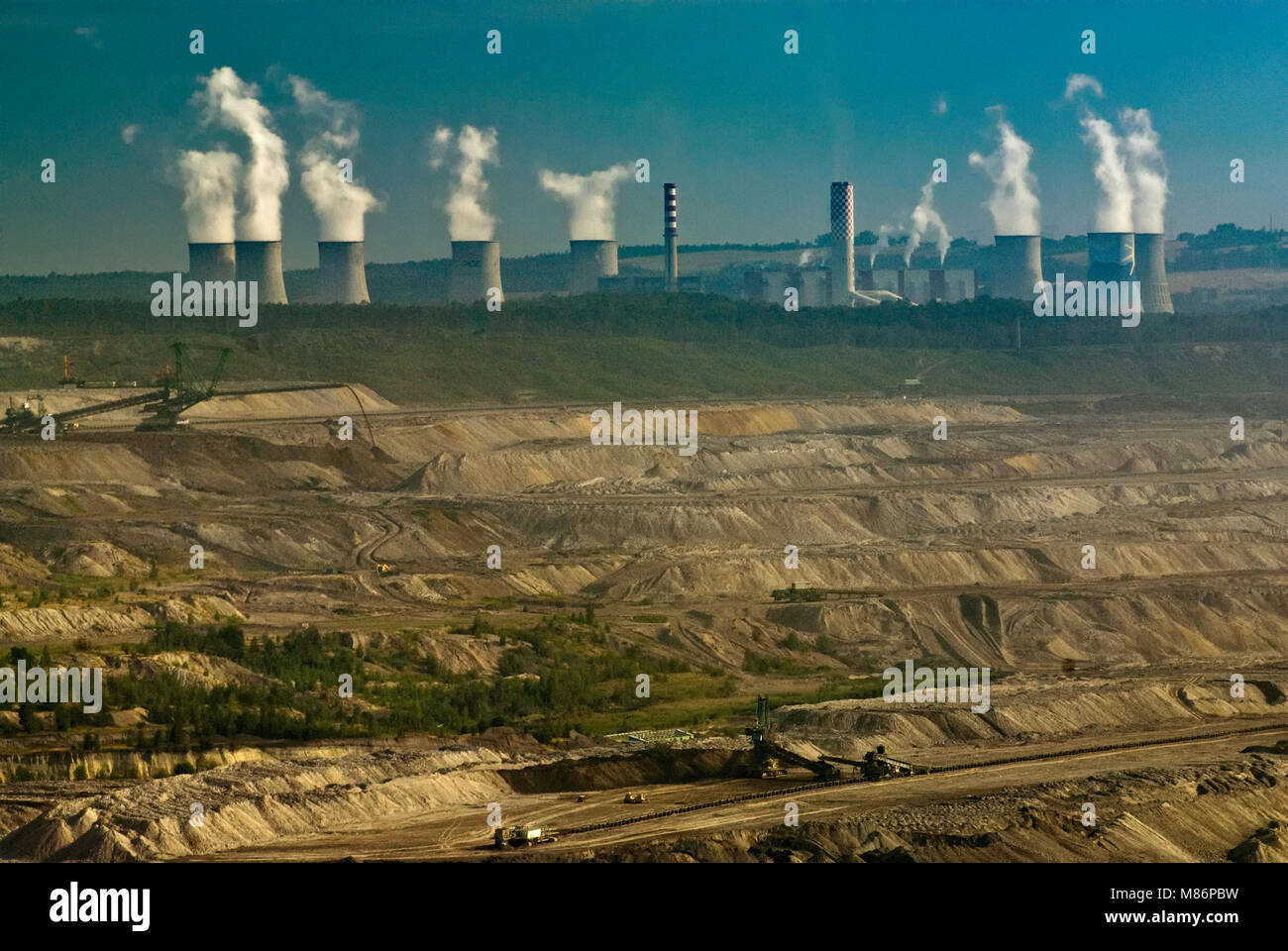 Cooling towers and chimney stacks at Turow thermal power plant over open-pit brown coal mine near Bogatynia in Lower Silesia region, Poland Stock Photo