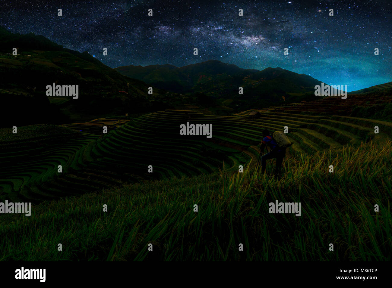 Landscape with Milky way galaxy. Night sky with stars and silhouette Photographer take photo over Rice fields on terraced in Mu Cang Chai. Long exposu Stock Photo