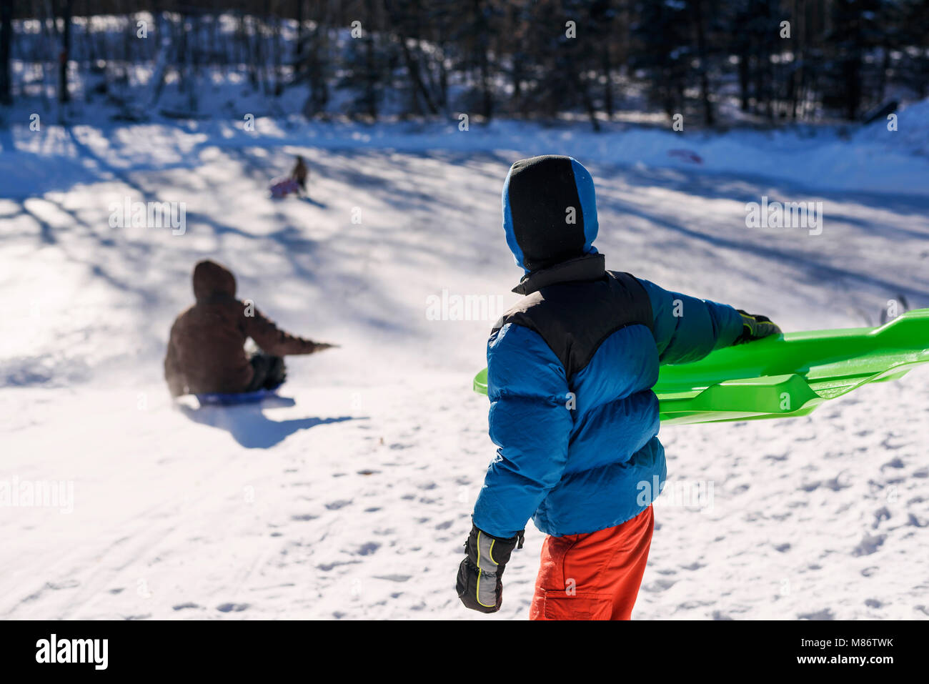 Boy sledging with his mother Stock Photo