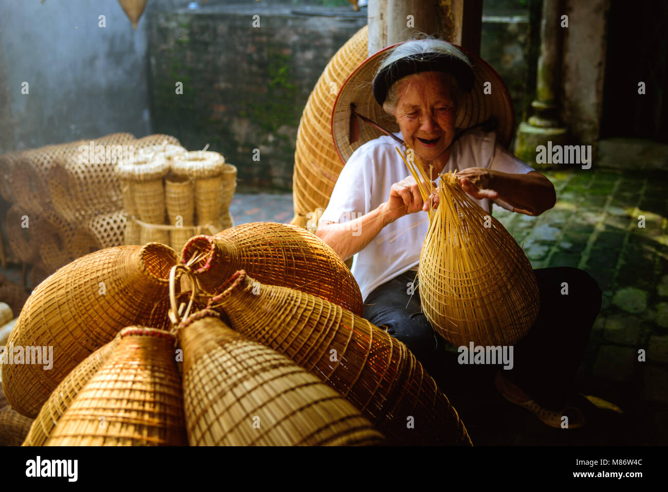 Vietnamese fishermen are doing basketry for fishing equipment at morning in Thu Sy Village, Vietnam. Stock Photo