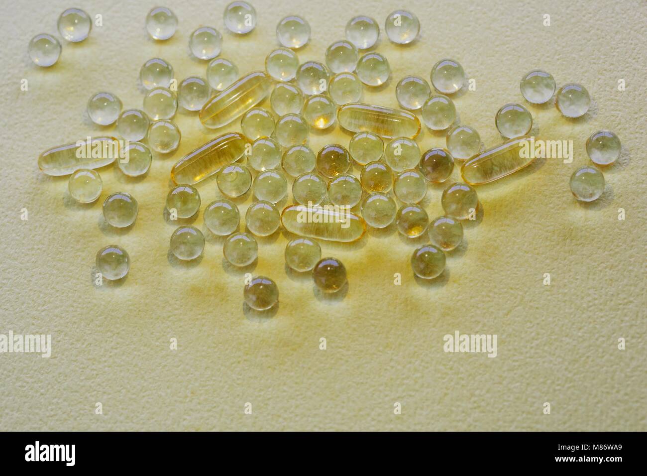 Yellow capsules on white background Stock Photo
