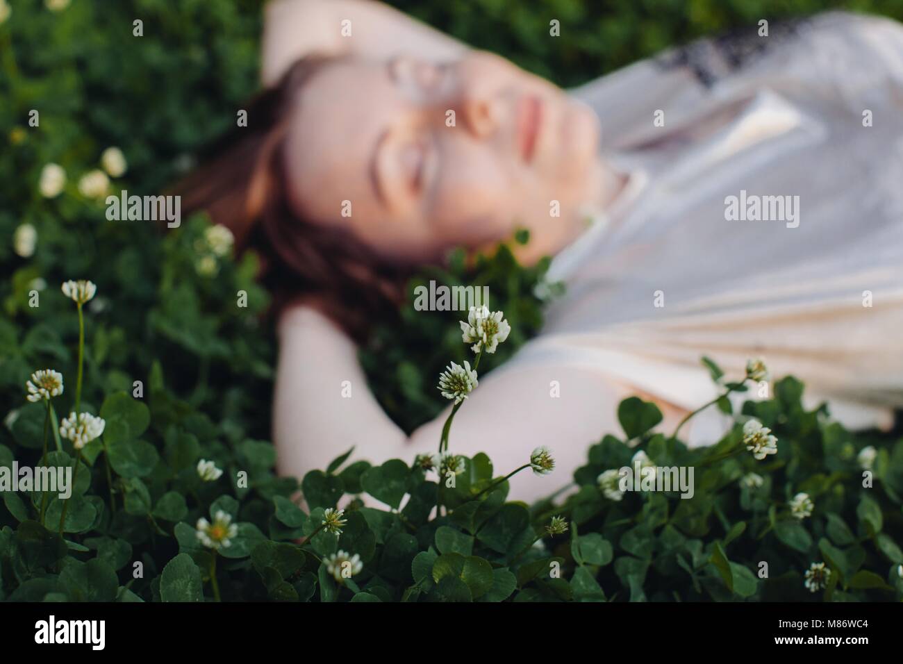 Woman lying on grass relaxing Stock Photo - Alamy